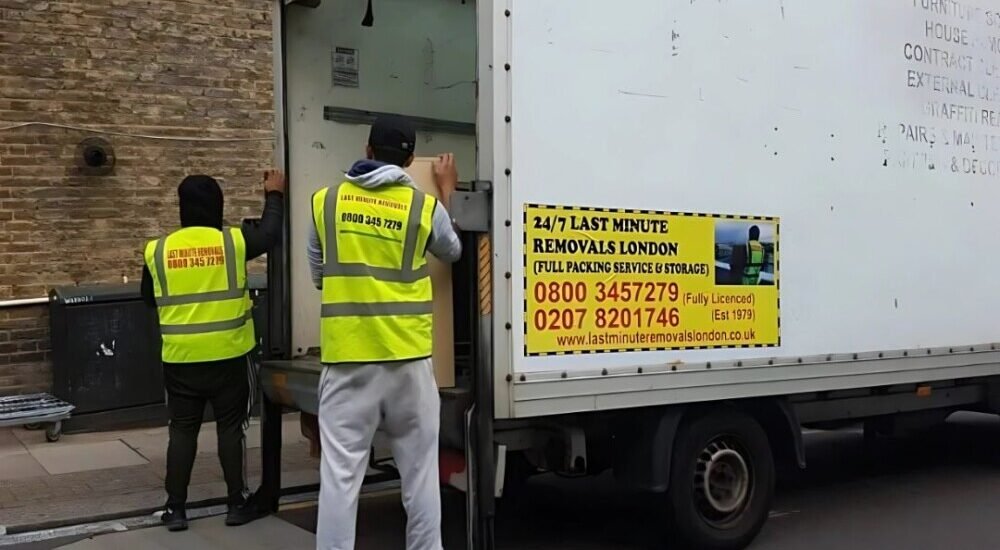 two workers of 24/7 Movers Packers London are loading the packed boxes into their professional van