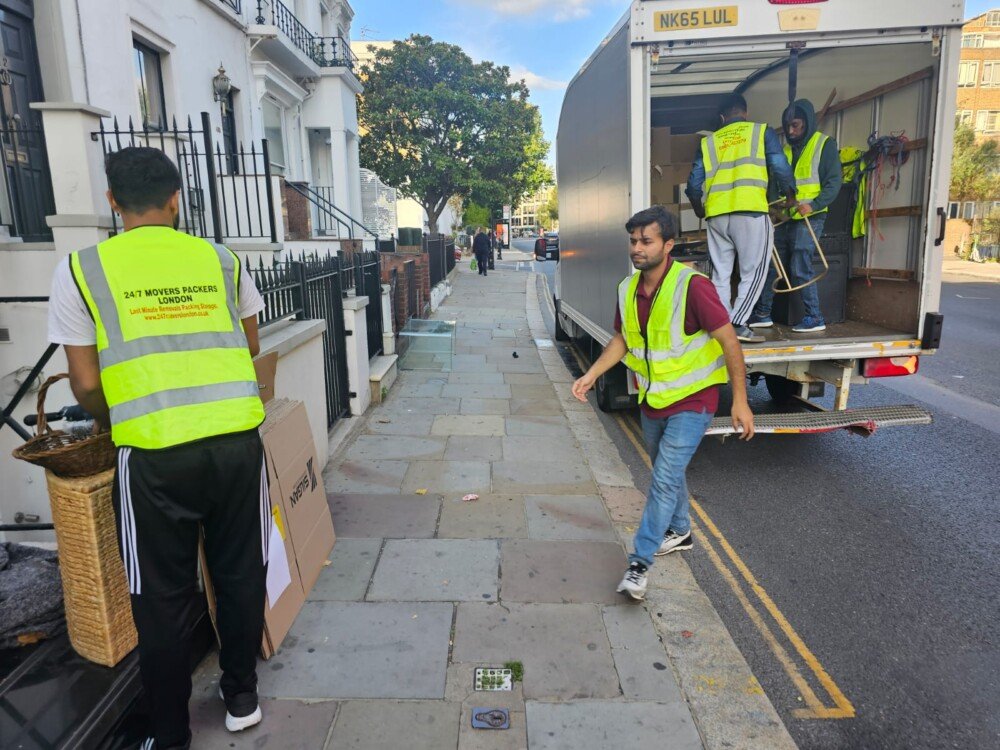24/7 Movers Packers London team loading and organizing boxes into a moving van on a residential London street during a house removal service.